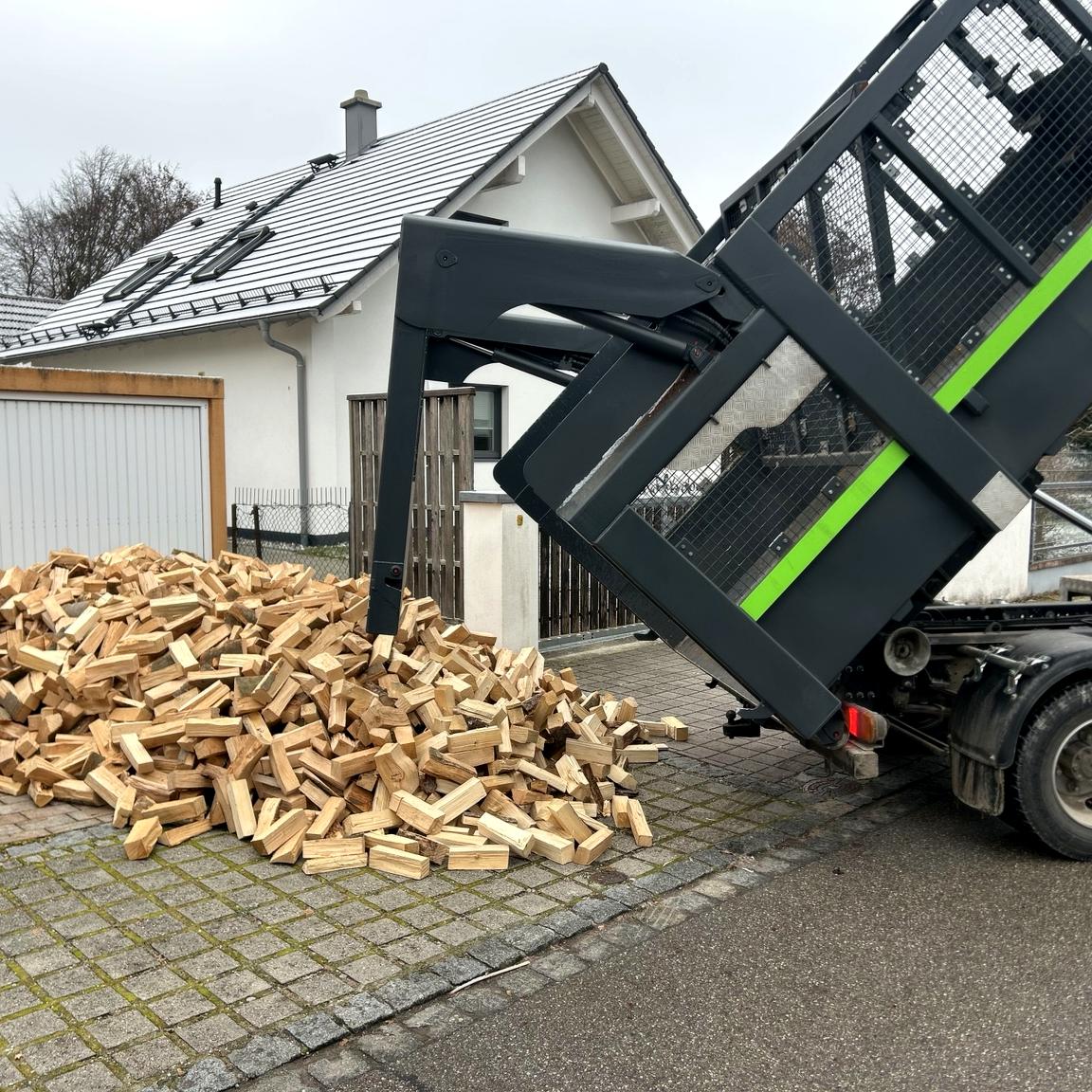 Brennholz Lieferung in München mit Kipper – ofenfertiges Kaminholz wird direkt auf die Einfahrt gekippt