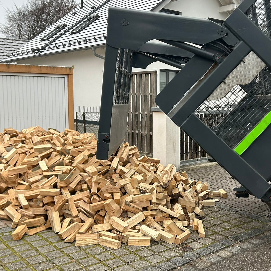 Brennholz aus regionalem Lieferdienst wird auf Lkw vor Garageneinfahrt in Puchheim abgeladen